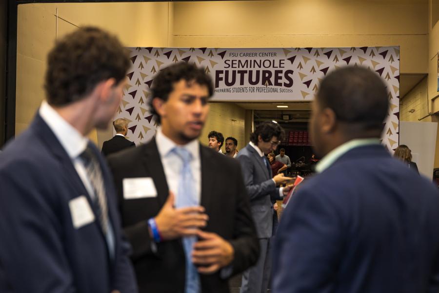 students talking to employers in foreground and seminole futures walkway in background