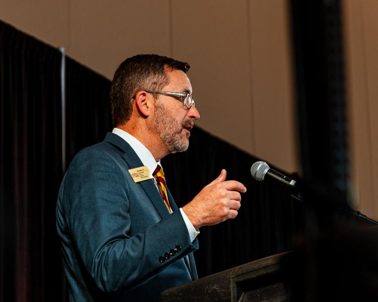 A speaker (Rob Liddell) at a podium