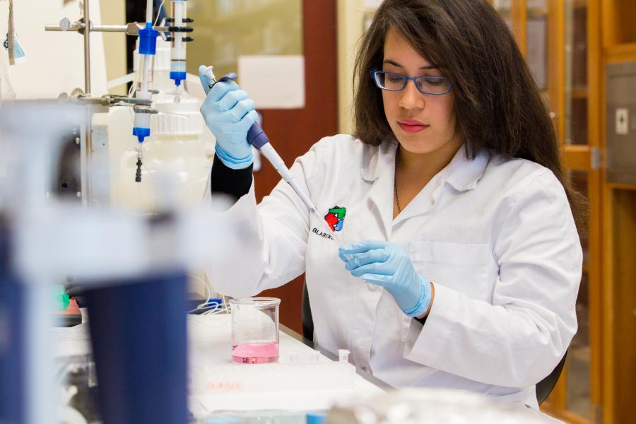 A person working with chemicals, seemingly titration